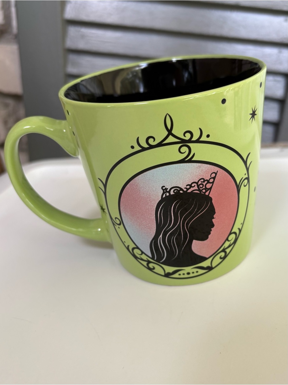 Wicked coffee cup features green ceramic finish with elphaba silhouette profile